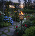 Gartenfackel auf Stab mit Lilienmuster und brennender Flamme