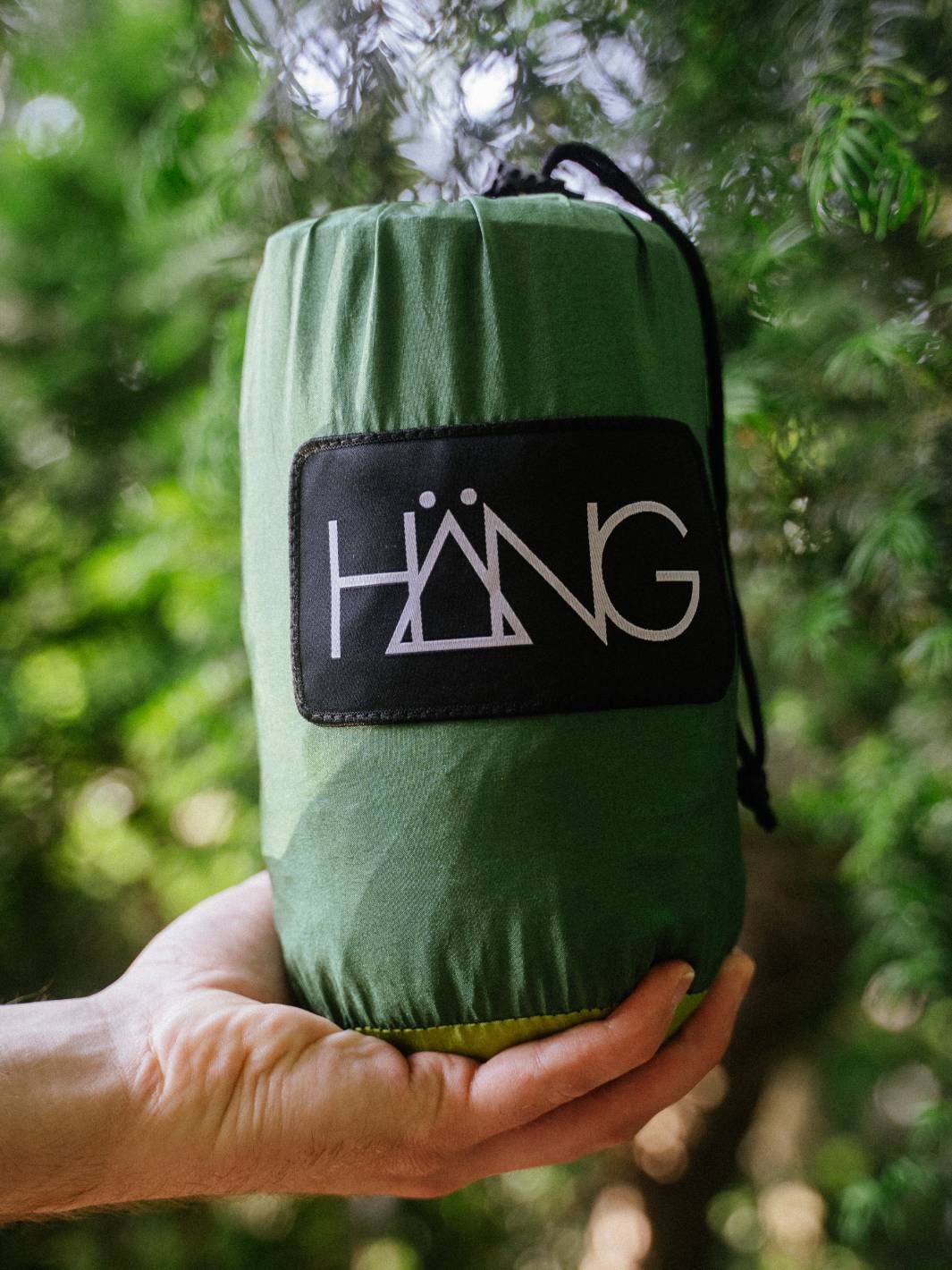 Grüner HÄNG Stuffsack mit Logo, in Händen gehalten