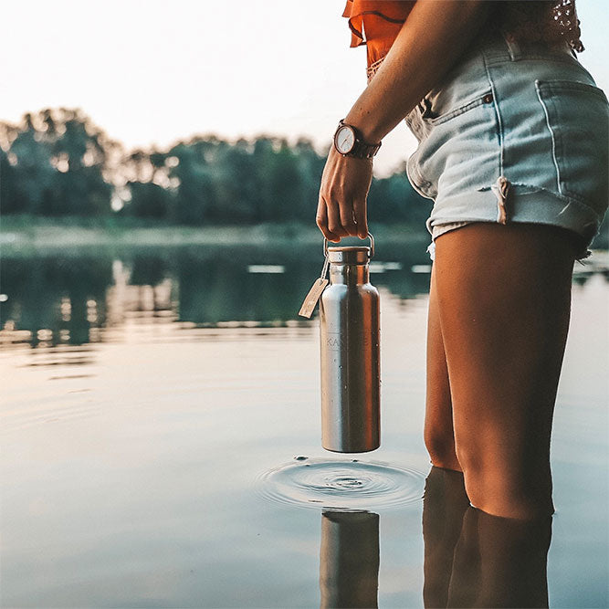 Isolierflasche aus Edelstahl in der Hand mit Korkdeckel