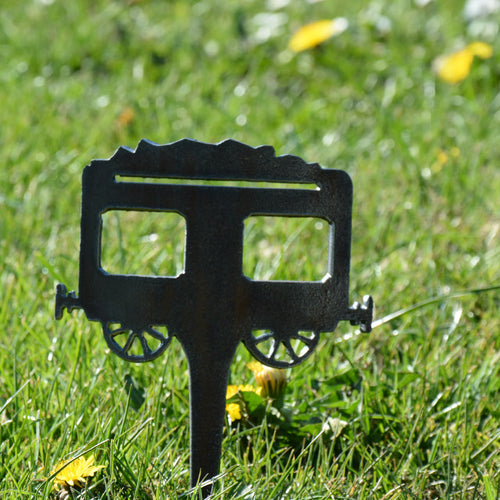 Gartenstecker in Form eines Kohlewagens, schwarzer Metallstecker mit zwei Rädern.