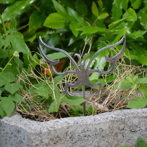 Silberner Gartenstecker mit Schmetterlingsmotiv aus Metall, auf einem Stab im Boden