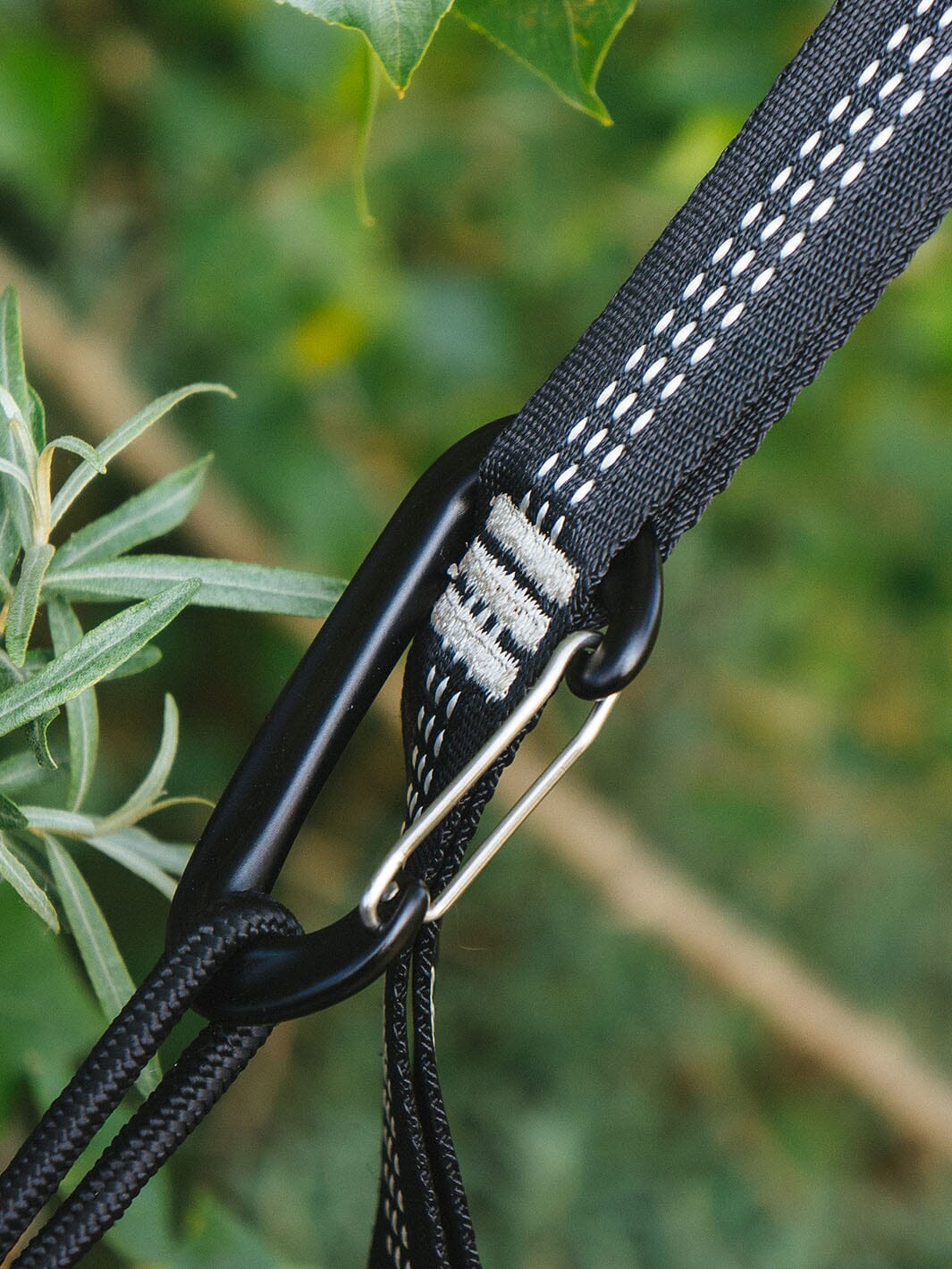 Schwarzer Aufhängegurt mit Karabiner und Nahtdetail der Hängematte