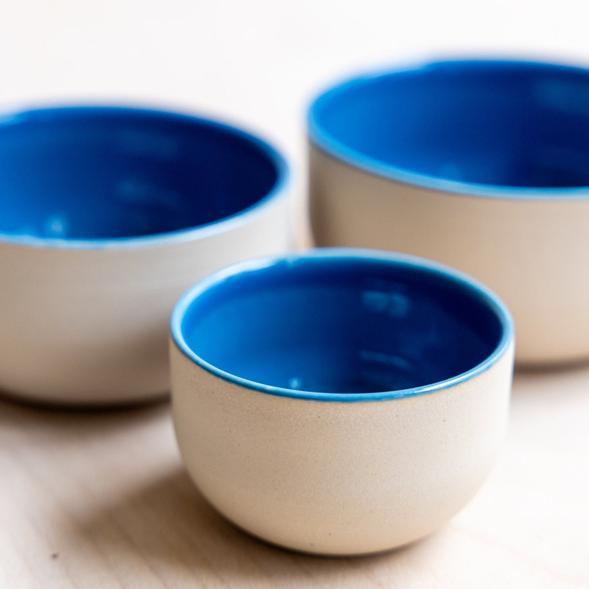 Zwei beige Keramik-Tassen mit blauem Innen