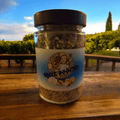 Luigis griechischer Booster im Glasbehälter mit schwarzem Deckel und Etikett.