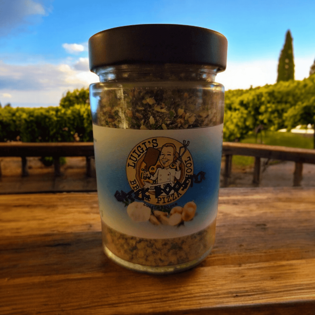 Luigis griechischer Booster im Glasbehälter mit schwarzem Deckel und Etikett.