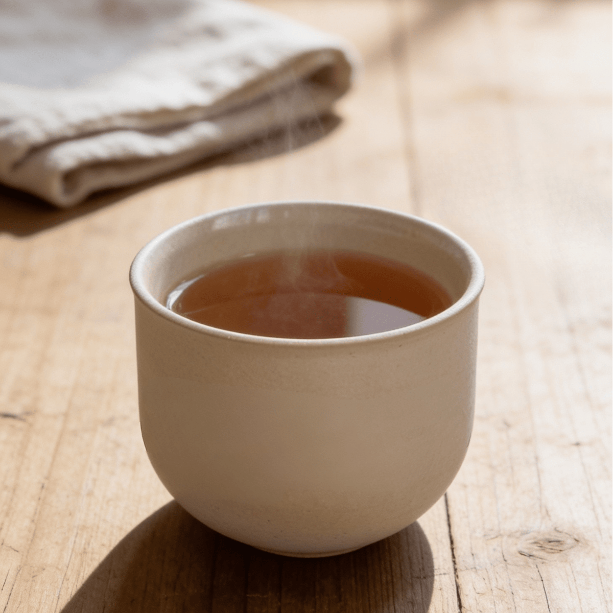 Beige Teetasse mit Heißgetränk, runde Form